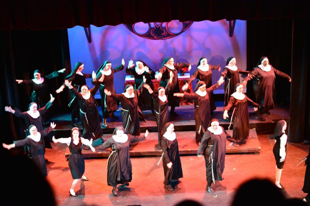 Women dressed as nuns and dancing onstage.