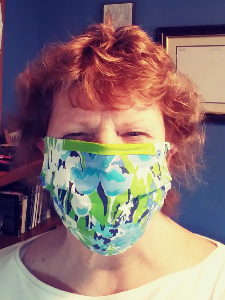 Woman's face (mine) wearing a floral cotton face mask.